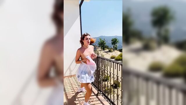 Bella Thorne taking on a balcony taking her top off
